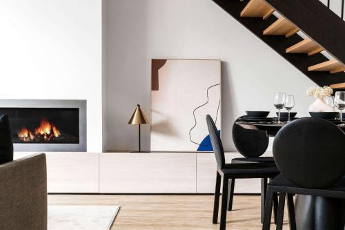 a living room with a fireplace and a table and chairs at A Lux 3BR Townhouse in South Yarra FREE Parking in Melbourne