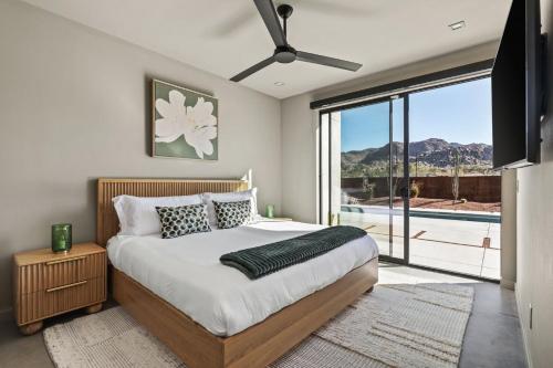 Un dormitorio con una cama y una ventana grande. en Suncrest by Fieldtrip JT Modern w Pool and Views, en Joshua Tree