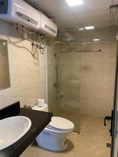 a bathroom with a shower and a toilet and a sink at Sapa Crown Hotel in Sapa