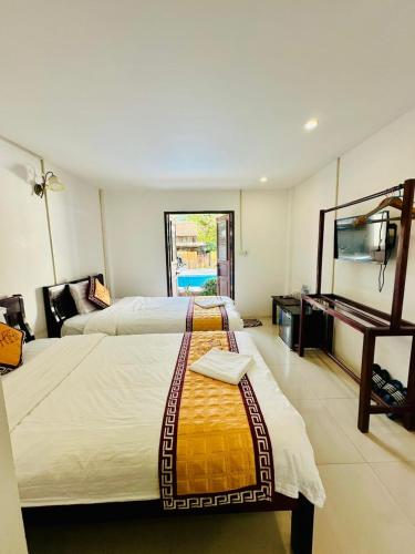 a hotel room with two beds and a television at Luangprabang Residence Boutique Hotel in Luang Prabang
