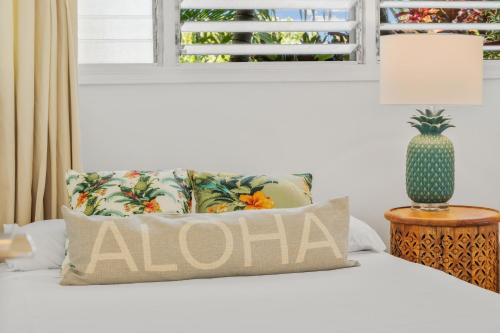 a bed with a pillow with a cactus on it at International Colony Club 37 · ICC 37 Remodeled Hawaiian Cottage in Kaanapali