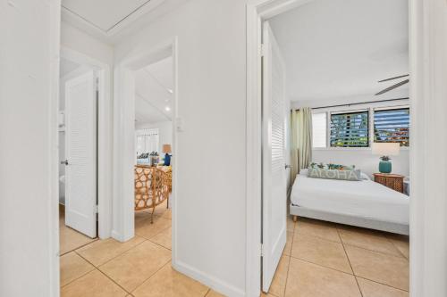 a white bedroom with a bed and a window at International Colony Club 37 · ICC 37 Remodeled Hawaiian Cottage in Kaanapali