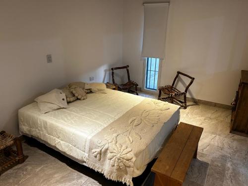 ein Schlafzimmer mit einem Bett und zwei Stühlen und einem Tisch in der Unterkunft Casa de Campo La Justina in Maco