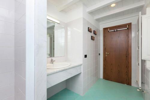a white bathroom with a sink and a mirror at Podere Montestuccioli in Cutigliano