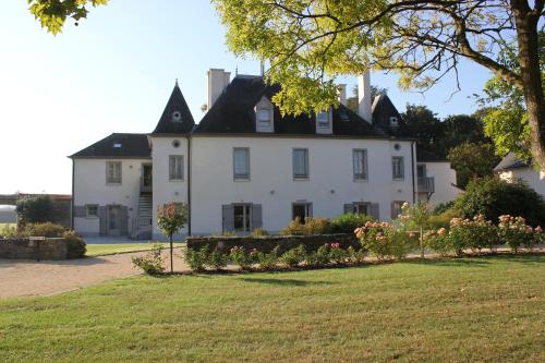 a large white house with a black roof at La Pommeraie in Bruz