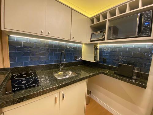 a kitchen with a sink and a microwave at Ninety Stay Premium in Sao Paulo