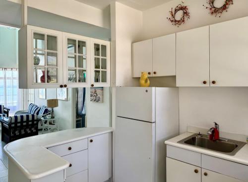 a kitchen with white cabinets and a sink at Sunset Cove - Vacation In Paradise! in Nassau