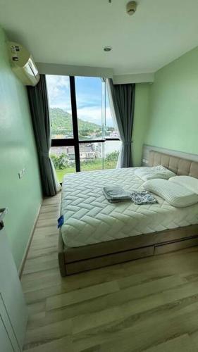 a bedroom with a bed and a large window at The Base Hight 一卧公寓 in Phuket Town