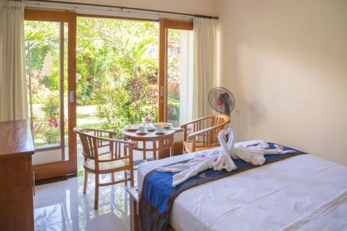 pokój z łóżkiem, stołem i oknem w obiekcie Chandra House Ubud w mieście Ubud