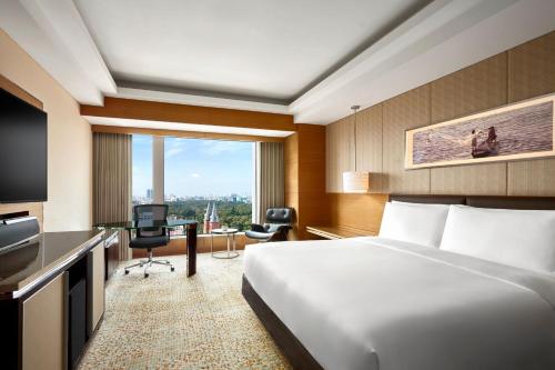 a hotel room with a bed and a desk at JW Marriott Hotel and Suites Saigon in Ho Chi Minh City