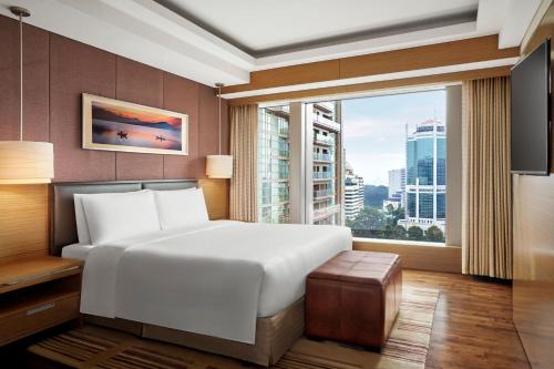 a bedroom with a large bed and a large window at JW Marriott Hotel and Suites Saigon in Ho Chi Minh City