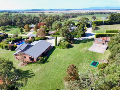 an aerial view of a house on a large grass field at Prom Coast Holiday Lodge in Waratah Bay
