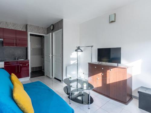 un salon avec un canapé bleu et une table en verre dans l'établissement Appartement au Coeur de Mimizan Plage pour 4 Personnes, à Proximité des Commerces et Plages - FR-1-50-142, à Mimizan