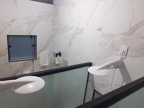 a bathroom with marble walls and a sink and a mirror at Chalés Recanto na Serra in Gonçalves