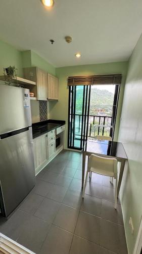 a kitchen with a stainless steel refrigerator and a table at The Base Hight 一卧公寓 in Phuket Town