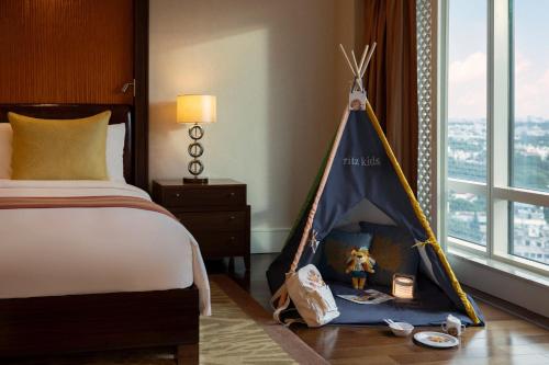 a bedroom with a bed with a tent next to a window at The Ritz-Carlton, Bangalore in Bengaluru