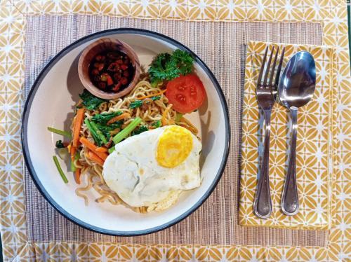 a plate of food with an egg and noodles at Private Pool Jungle View Villa in Kaba-Kaba in Tabanan