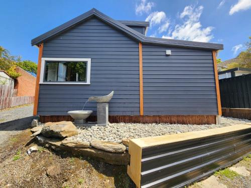 a blue house with a toilet in front of it at A Stone's Throw From Town Tiny Home in Dunedin