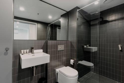 ベルコナンにあるBeautiful 2BR Lakeside Viewの洗面台、トイレ、鏡のあるバスルーム