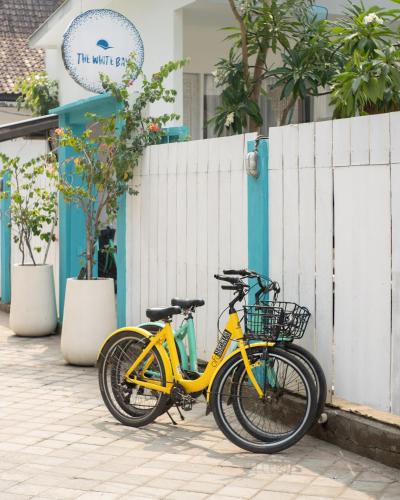 a yellow bike parked next to a fence at The White Bay in Gili Trawangan