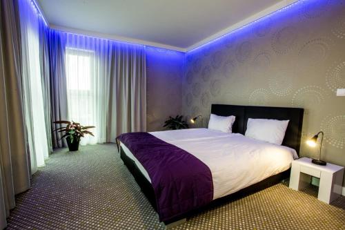 ヴロツワフにあるHubska Apartmentsのベッドルーム(紫色の照明付きのベッド1台付)