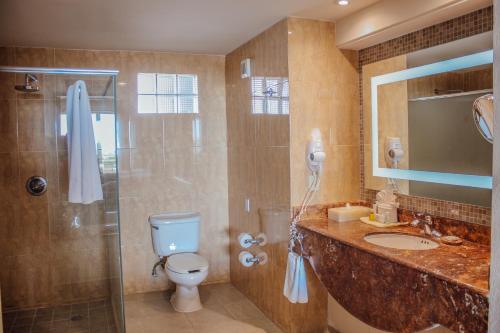 a bathroom with a shower and a toilet and a sink at GR Solaris Lighthouse - All Inclusive in San José del Cabo