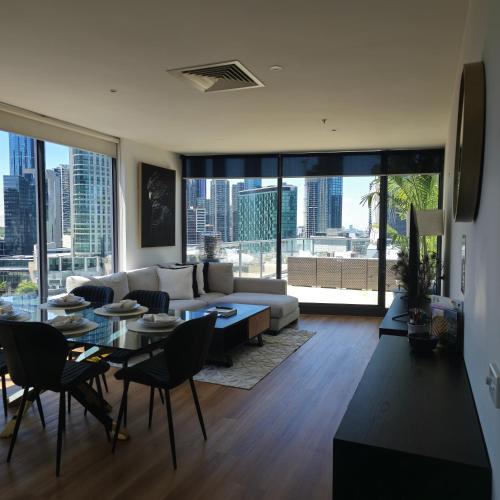 a living room with a couch and a table and chairs at Pristine on Flinders in Melbourne