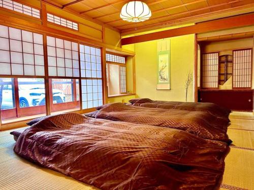 a large bed in a room with windows at villa the rise hakodate in Hakodate