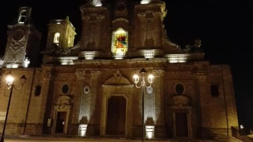 a large stone building with a clock tower at night at Domusfrumenti in Oria