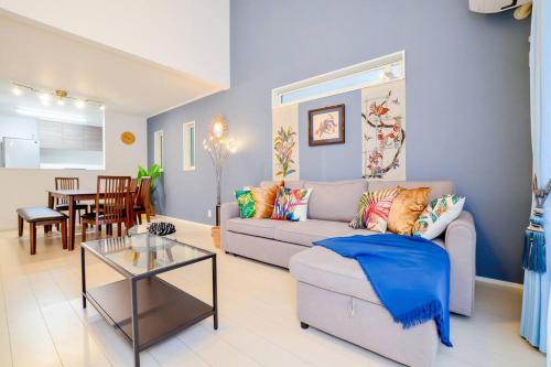 a living room with a couch and a table at Villa Fukugi in Motobu