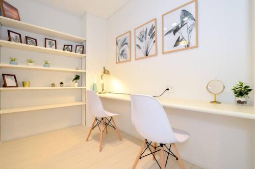 two white chairs in a room with shelves at Villa Fukugi in Motobu