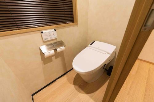a small bathroom with a toilet and a window at Hotel Paul House in Tokyo