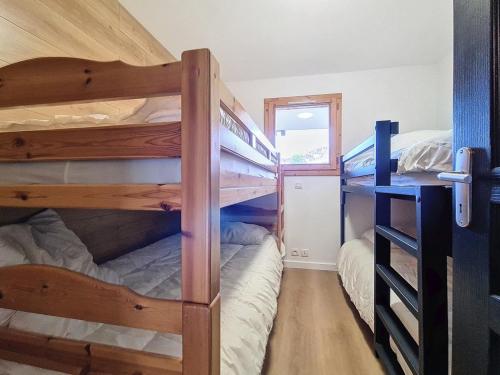 Cette petite chambre dispose de 2 lits superposés et d'une fenêtre. dans l'établissement Appartement rénové 2P, balcon sud-ouest, pied des pistes, parking, wifi, non fumeur. - FR-1-344-1215, aux Bruyères