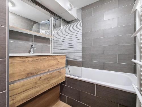 une salle de bain avec une baignoire et un lavabo dans l'établissement Appartement rénové 2P, balcon sud-ouest, pied des pistes, parking, wifi, non fumeur. - FR-1-344-1215, aux Bruyères