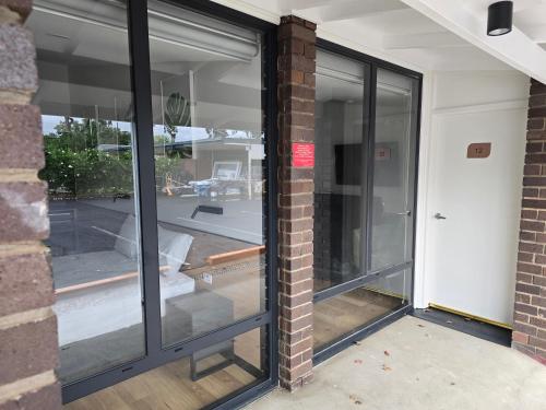 a group of glass doors on a brick wall at Parkview Motor Inn in Parkes