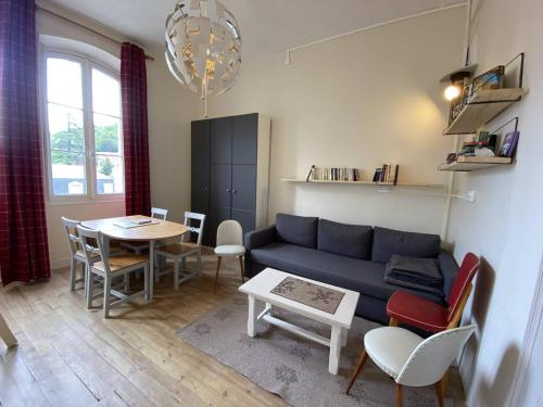 un salon avec un canapé et une table dans l'établissement Appartement rénové à Cauterets avec parking privé - FR-1-812-47, à Cauterets
