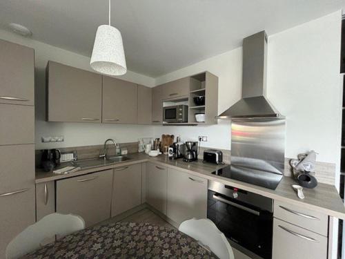 une cuisine avec un évier et une cuisinière four supérieur dans l'établissement Chalet élégant au centre de Cauterets avec terrasse - FR-1-812-51, à Cauterets