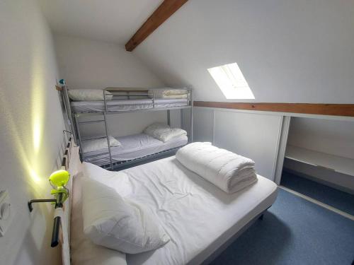 Cette chambre comprend un lit superposé avec des draps et des oreillers blancs. dans l'établissement Chalet 2 chambres à Cauterets avec parking - FR-1-812-56, à Cauterets