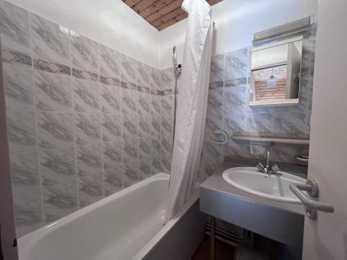 une salle de bain avec un lavabo et une baignoire et un lavabo dans l'établissement Chalet familial à Cauterets avec chambres spacieuses - FR-1-812-58, à Cauterets