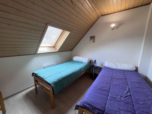 une chambre mansardée avec deux lits et une fenêtre dans l'établissement Chalet T4 à Cauterets avec parking et terrasse - FR-1-812-11, à Cauterets