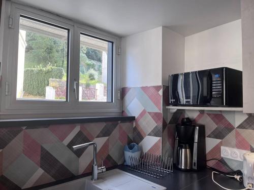 une cuisine avec un évier et un micro-ondes dans l'établissement Charmant duplex avec deux coins nuit au cœur de Cauterets - FR-1-812-14, à Cauterets