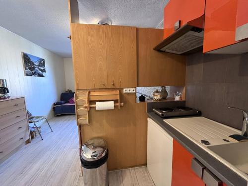 une cuisine avec des armoires en bois et un comptoir dans l'établissement Studio cosy proche télécabines avec parking - FR-1-812-5, à Cauterets