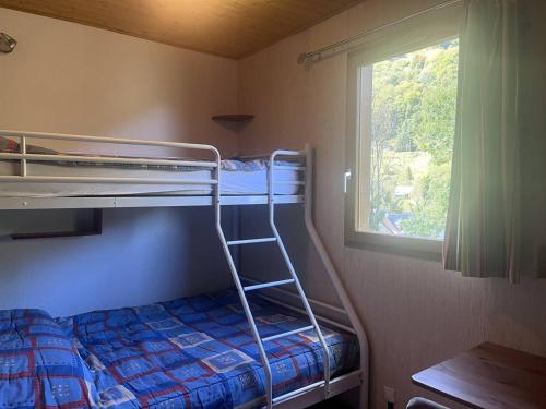une chambre avec deux lits superposés et une fenêtre dans l'établissement Chalet confortable à Cauterets avec parking et balcon - FR-1-812-10, à Cauterets