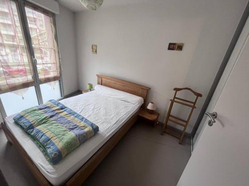 une petite chambre avec un lit et une chaise dans l'établissement Charmant appartement à Cauterets avec parking et proche des pistes - FR-1-812-52, à Cauterets