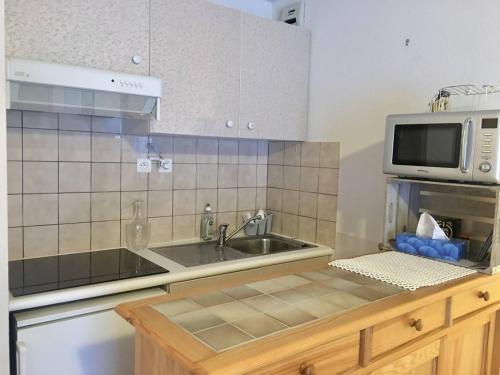 une cuisine avec un évier et un micro-ondes dans l'établissement Appartement à Cauterets avec balcon et vue sur les montagnes - FR-1-812-53, à Cauterets