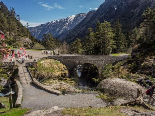 un pont sur une rivière avec une montagne dans l'établissement Charmant appartement à Cauterets avec parking et proche des pistes - FR-1-812-52, à Cauterets