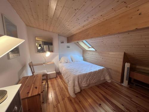une chambre avec un lit et un plafond en bois dans l'établissement Appartement 2 chambres avec mezzanine, au cœur de Cauterets - FR-1-812-22, à Cauterets