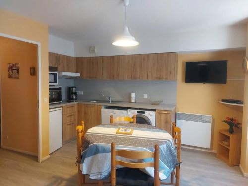 a kitchen with a table and chairs in a room at Appartement lumineux avec parking et cellier à skis - FR-1-812-23 in Cauterets