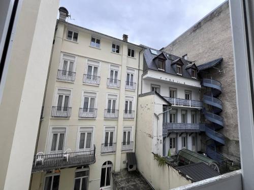 - un grand bâtiment blanc avec des balcons sur le côté dans l'établissement Doux séjour familial à Cauterets - FR-1-812-55, à Cauterets