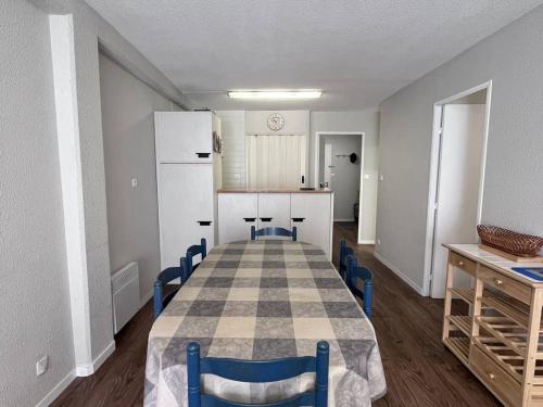 une pièce avec une table et des chaises et une cuisine dans l'établissement Confort moderne à Cauterets : T2 avec cuisine équipée et alcôve. Capacité 4 pers. - FR-1-812-57, à Cauterets